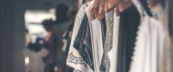 Een kledingrek met kleding in zachte, lichte kleuren: groothandelsstrategie voor retail 