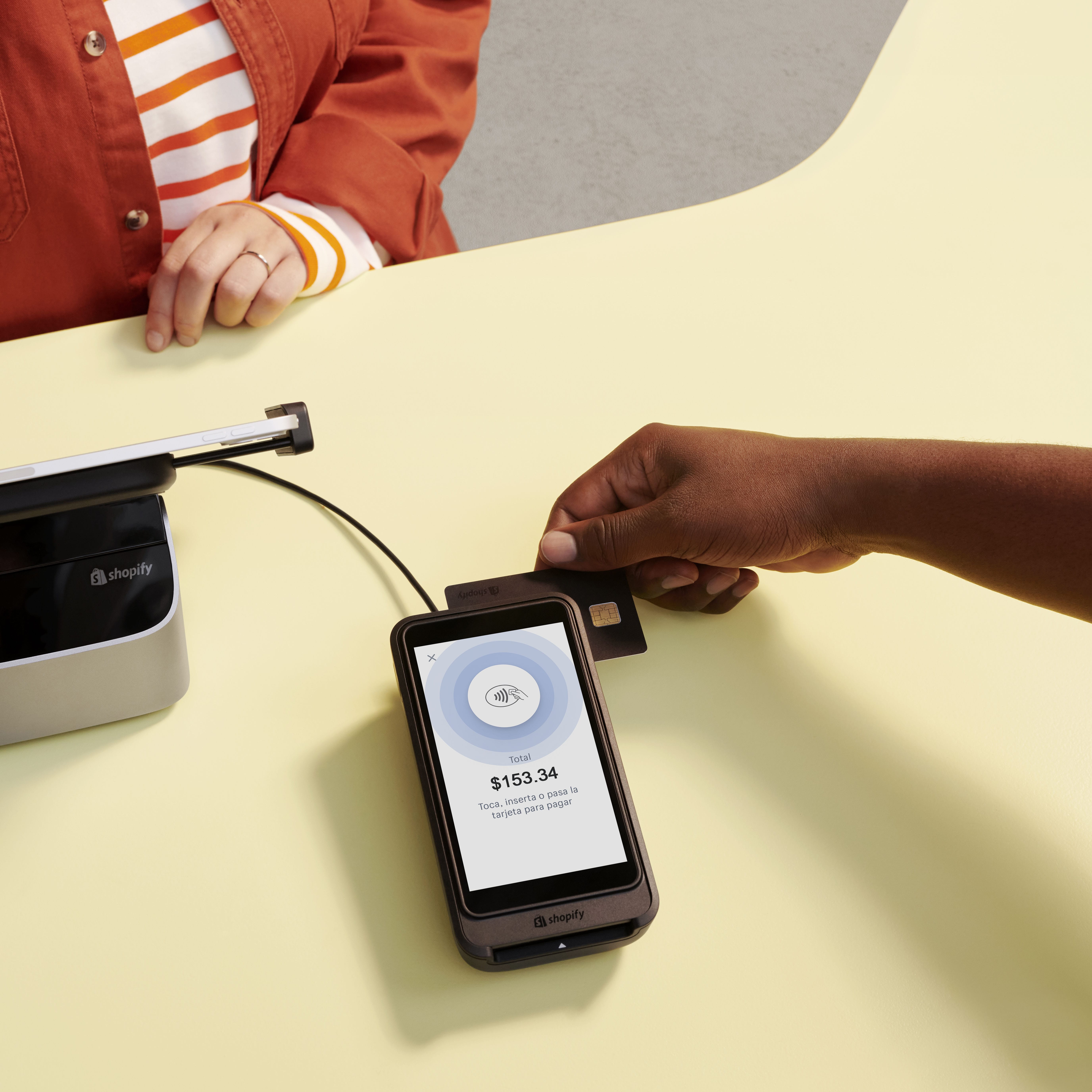Una tablet de POS en un mostrador de una tienda física ejecutando Shopify POS en la pantalla.