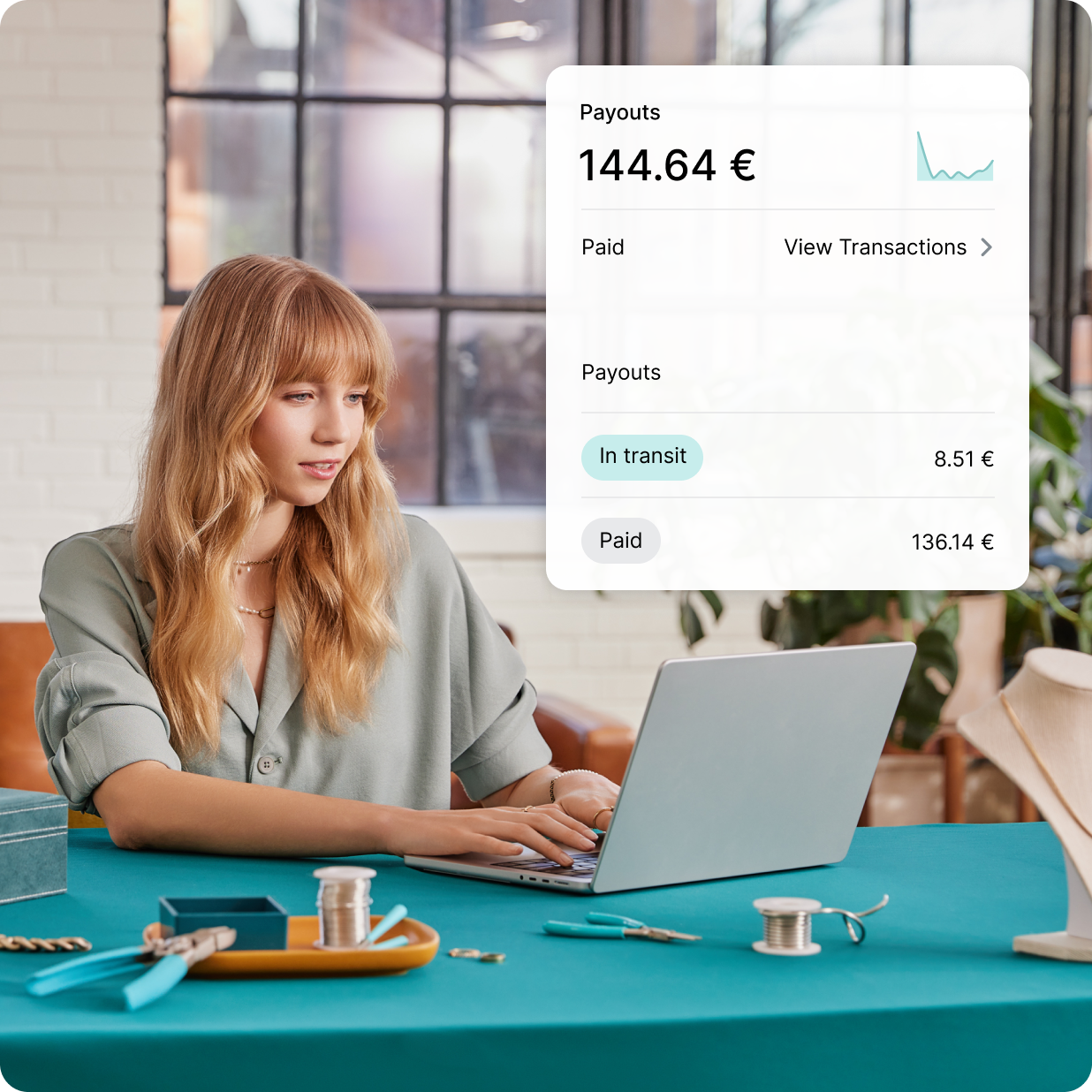 Emprendedora de Shopify blanca trabajando en su portátil para configurar Shopify Payments para su negocio de joyería.
