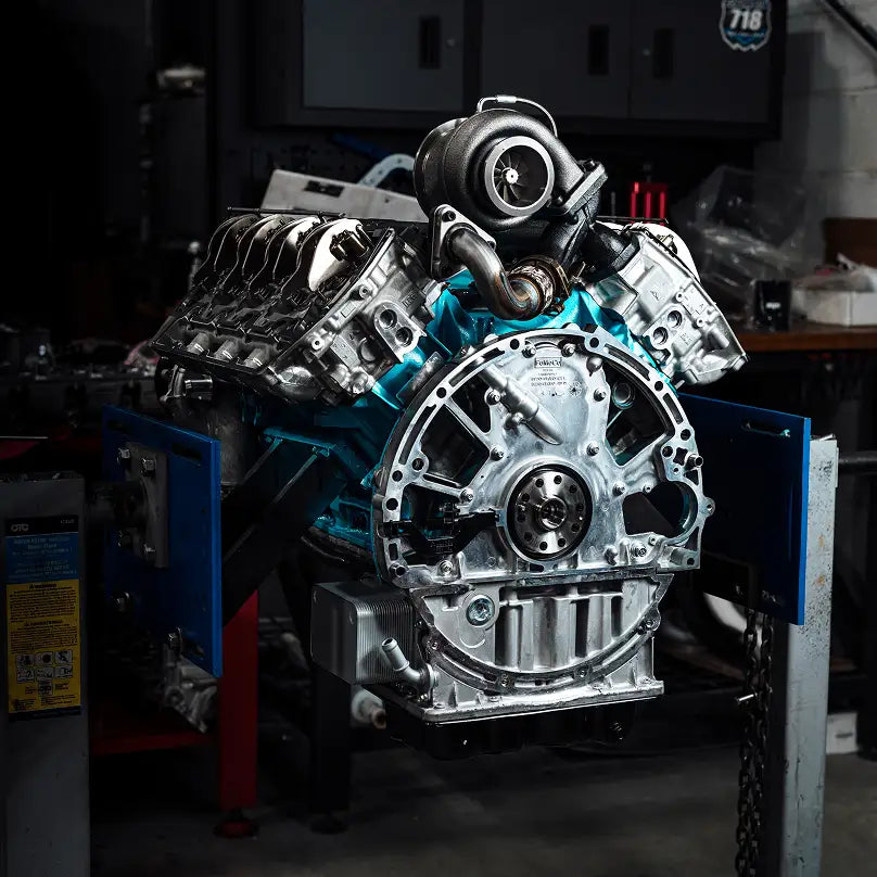 An image of a car engine being serviced in a mechanic shop.