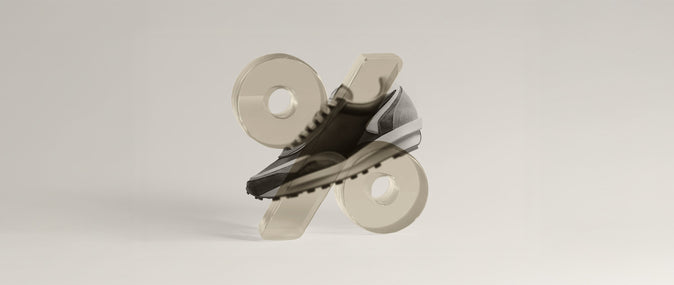 Clear percentage symbol  in front of an athletic shoe in front of a beige background
